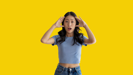 Asian woman acting shocked or surprised isolated on a Yellow background,  Looking camera, Concept...
