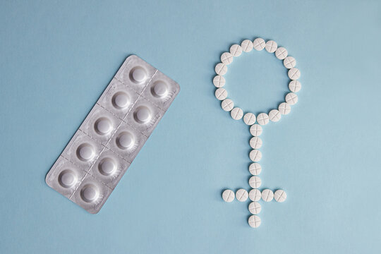 The female sign, the symbol of Venus, is laid out from the pills. Signs and symbols of women's health.