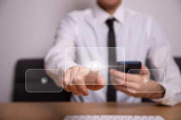 Video on demand technology with person touching play button on virtual screen to watch online VOD...