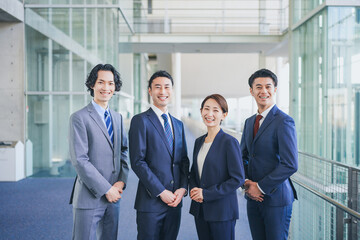 オフィスの廊下に並んで立つビジネスマンの男女