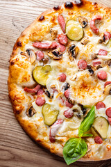 Pizza with Mozzarella cheese, salami, chicken meat, beef, ham, Tomato sauce, pepper, spices. Italian pizza on wooden background