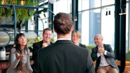 Obraz premium Team of colleagues office workers applauds to the successful company at meeting laughing and having fun in the office