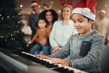 Boy child, music keyboard and christmas in family home with smile, playing and creative with happiness. Kid, young musician and parents by piano for holiday cheer, bond and song for pride in house