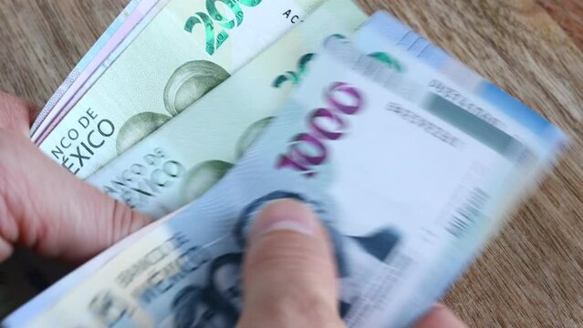 Mexico money, banknotes counting and flipping in hands, Mexican pesos currency, financial and economic concept