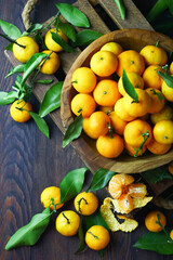 Mandarin orange on rustic wooden bowl and dark wooden background. 