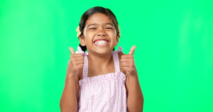 Happy, green screen and face of a child with thumbs up for excitement isolated on a studio background. Success, review and portrait of a girl showing an emoji hand icon for satisfaction and like