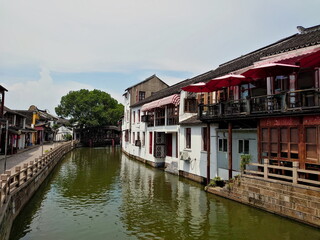 Shanghai, China - Jul 25, 2018: A view of the riverside of Zhujiajiao, a traditional Chinese town, from a bridge of its traditional architecture and an empty sidewalk before the pandemic