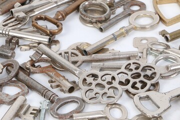 close up of a heap of different old keys on a white ground