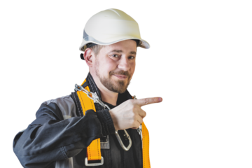 Positive friendly bearded male builder in overalls, hardhat and goggles pointing with his finger. Isolated background.