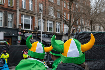 Irish flag viking hats in the crowd, people in the street with costumes, green, Paddy's day parade in Dublin city center, Ireland