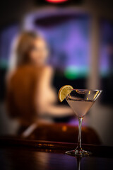 blurred topled women next to focued martini glass