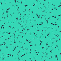 Black Christmas candy cane with stripes icon isolated seamless pattern on green background. Merry Christmas and Happy New Year. Vector