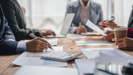 Using laptop pc, Team of lawyers and tax auditors brainstorming together and calculating the balance sheet and historical financial accounts of the company and shareholders.