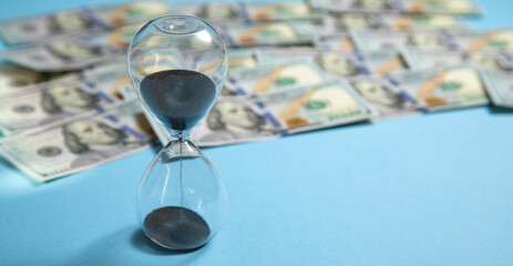 Hourglass with a dollar banknote. Business