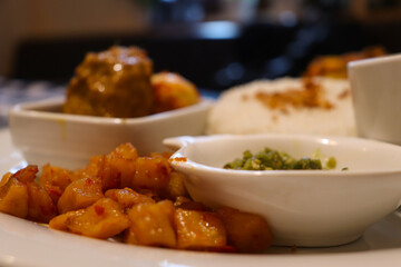 A Complete Dish of Padangnese Food with Rendang, Spicy Potato, Rice, Green Chilies, Balado Egg, and Vegetable Curry Soup from Indonesia