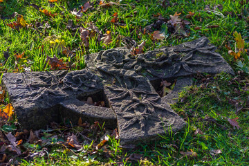 Naklejka na ściany i meble A broken Celtic Cross gravestone on the ground at New Southgate Cemetery, London, UK.