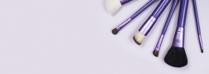 beauty makeup product layout. Fashion woman makeup brushes on violet background. Stylish design background. Creative fashion concept. Cosmetics makeup brushes collection, top view, banner