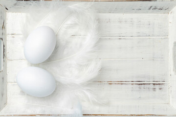 Easter white eggs on a white wooden background. Minimal concept. View from above. Card with copy space for text