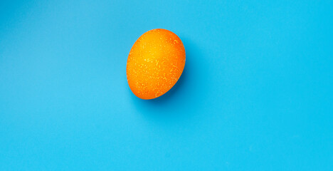Easter background with yellow Easter eggs and spring flowers on a blue background. Top view, space for text, banner