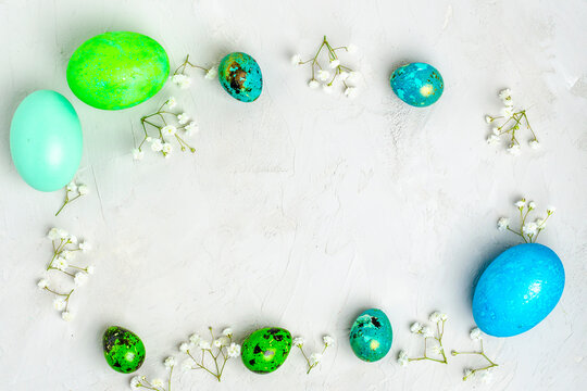 Banner. Easter frame with eggs and flowers on a white concrete background. Minimal concept. View from above. Card with copy space for text.