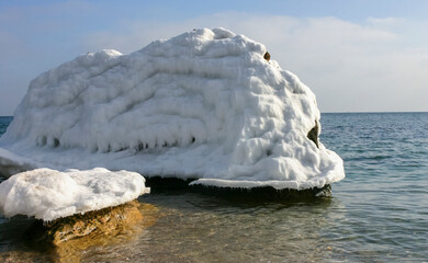 Iced rocks and stones near the shore in the Black Sea at the end of winter