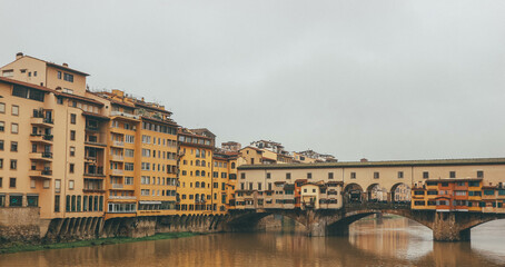 Colorful buildings by the river in italian town and medieval famous bridge