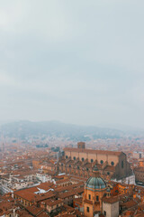 Fototapeta na wymiar Top view of terracota roofs and medieval dome in italian town