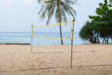 Empty volleyball court for beach volleyball on a sandy beach by the sea. Stretched volleyball net...