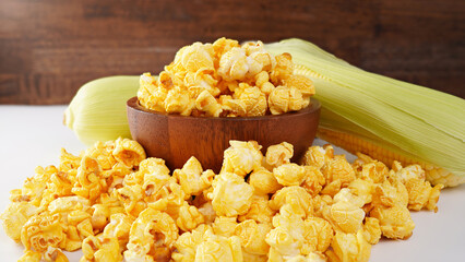 Caramelized popcorn in a wooden cup on a close-up, white backgrod