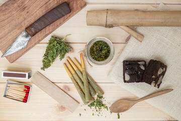 marijuana with drug paraphernalia on wood background