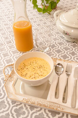 Chopped view of a fish soup served in a dish with juice on a tablecloth.
