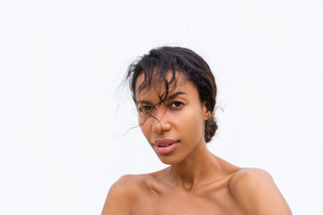 Fototapeta na wymiar Beauty portrait of young topless african american woman with bare shoulders on white background with perfect skin and natural makeup positive