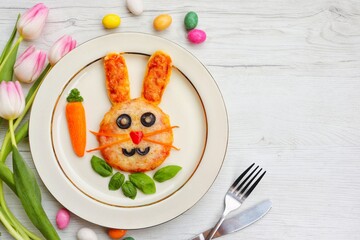 Mini Easter bunny pizza on plate with white wood background.Art food idea for kids Easter's party.Top view.Copy space