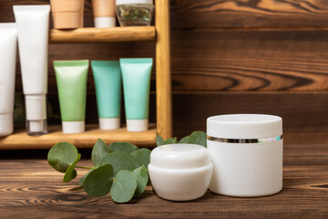 Shelf with care cosmetics in the bathroom on a brown wood background. Washing gel, toner, serum and body cream. Cosmetic tube. Decorative and care cosmetics.Beauty concept. Place for text.Copy space.