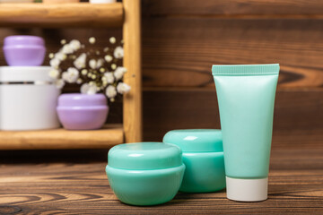 Shelf with care cosmetics in the bathroom on a brown wood background. Washing gel, toner, serum and body cream. Cosmetic tube. Decorative and care cosmetics.Beauty concept. Place for text.Copy space.