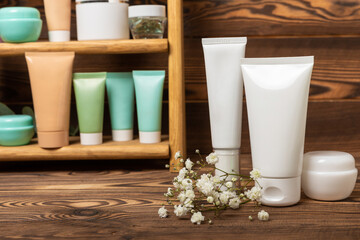 Shelf with care cosmetics in the bathroom on a brown wood background. Washing gel, toner, serum and body cream. Cosmetic tube. Decorative and care cosmetics.Beauty concept. Place for text.Copy space.