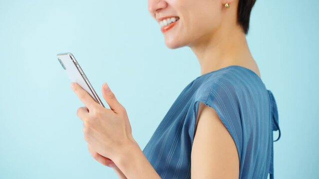 スマートフォンを使うワンピースを着た若い女性