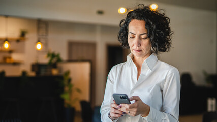 One mature woman use smartphone at home or at work frustrated mad