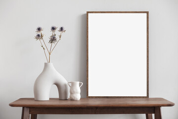 Obraz na płótnie Canvas Blank wooden picture frame mockup on wall in modern interior. Vertical artwork template mock up for artwork, painting, photo or poster in interior design