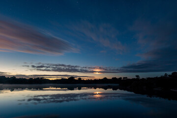 Fototapeta na wymiar Landscape at dawn with moon between clouds in Los Barruecos.