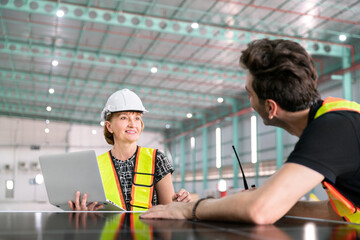 warehouse engineer solar cell clean energy storage check by technology notebook businessman and businesswoman engineer manager for storage and delivery transportation in factory of energy industry