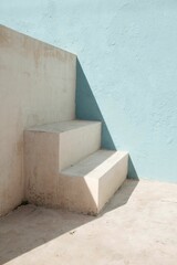 Vertical shot of a white concrete stairs on the corner of a blue and white wall