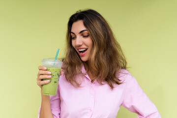 Young woman in casual wear isolated on green background positive vibes enjoying fresh ice green...