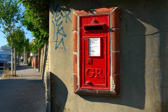 Red postbox on the wall with the GR Royal Cypher.