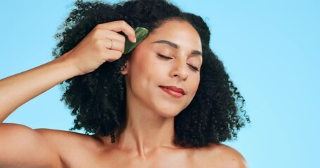 Beauty, gua sha and face of woman in studio for skincare, dermatology and cosmetics. Aesthetic female model for facial massage, self care glow and smooth skin on blue background with smile and shine