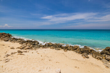 Fototapeta na wymiar Beautiful view of big rocks protecting sandy coastline. Turquoise water of Atlantic ocean. Aruba. 