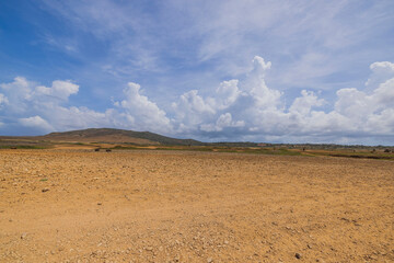 Beautiful view of stone desert of natural park on island of Aruba against backdrop of blue sky with white clouds.