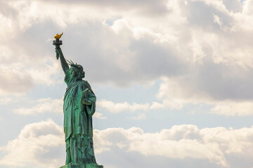 Fototapeta premium Beautiful view of famous Statue of liberty isolated on sky with white clouds background. New York, USA. 