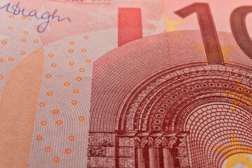 A macro image of the red microprint, sign, watermark on a Ten Euro banknote, emphasizing the advanced tamper-proof technology used to protect against fraud