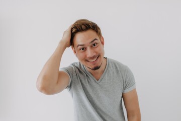 Asian man in grey t-shirt happy with his dyed hair isolated on white.